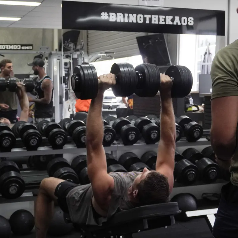 Member pressing dumbbells at Kaos Fitness