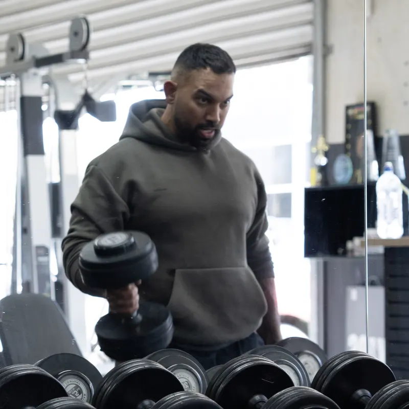 Member curling dumbbells at Kaos Fitness